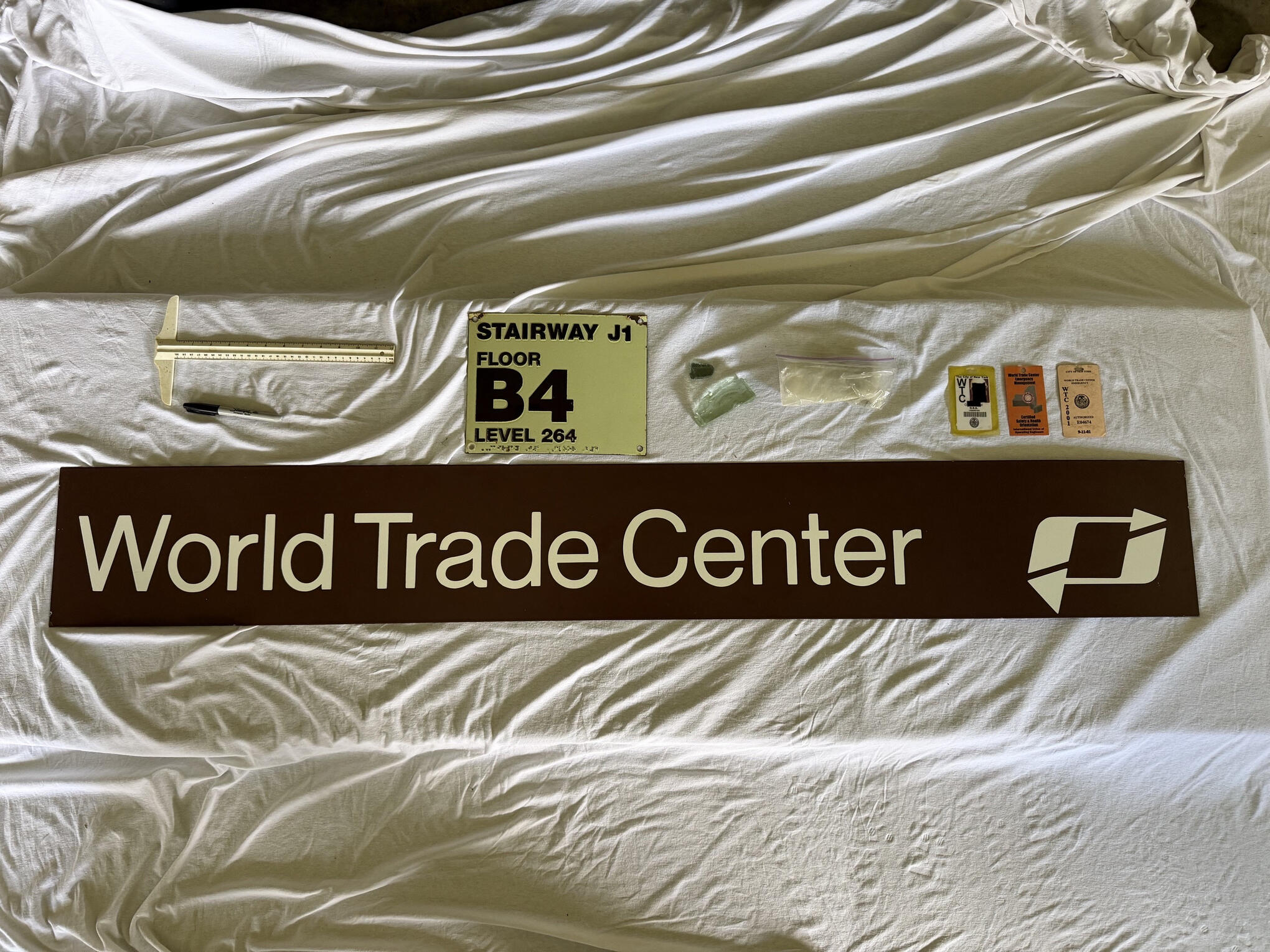 Historic World Trade Center Artifact Collection | Private Acquisition Original World Trade Center PATH Subway Sign, and directional sign with Stairway J1 floor marker and related recovered artifacts